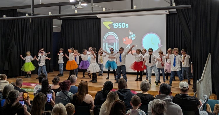 Children in costumes dancing on stage