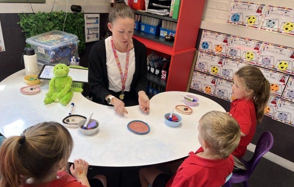 Teacher and students at desk learning