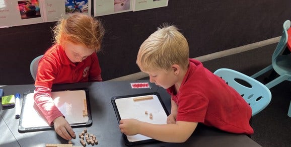 Students learning on whiteboards
