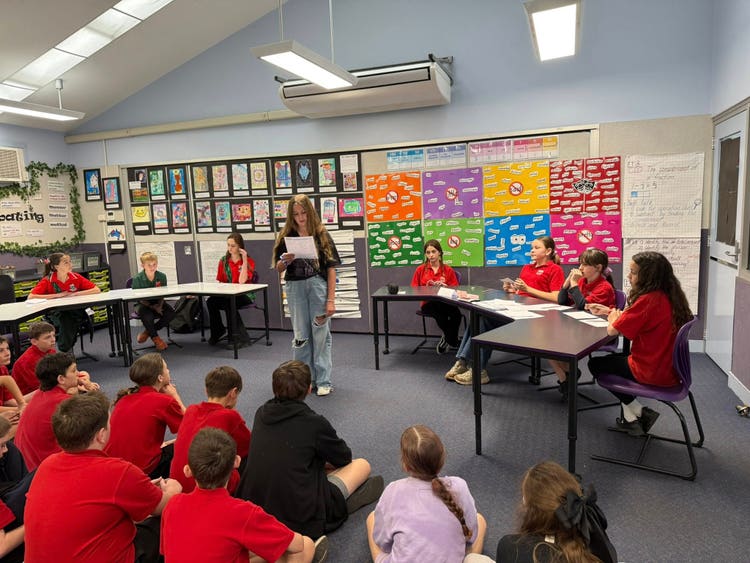 Children debating in classroom